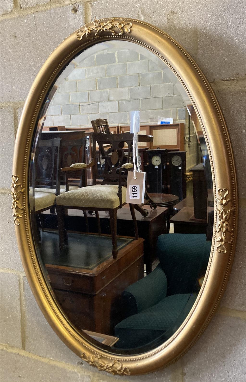 An early 20th century oval gilt framed wall mirror, width 55cm height 80cm